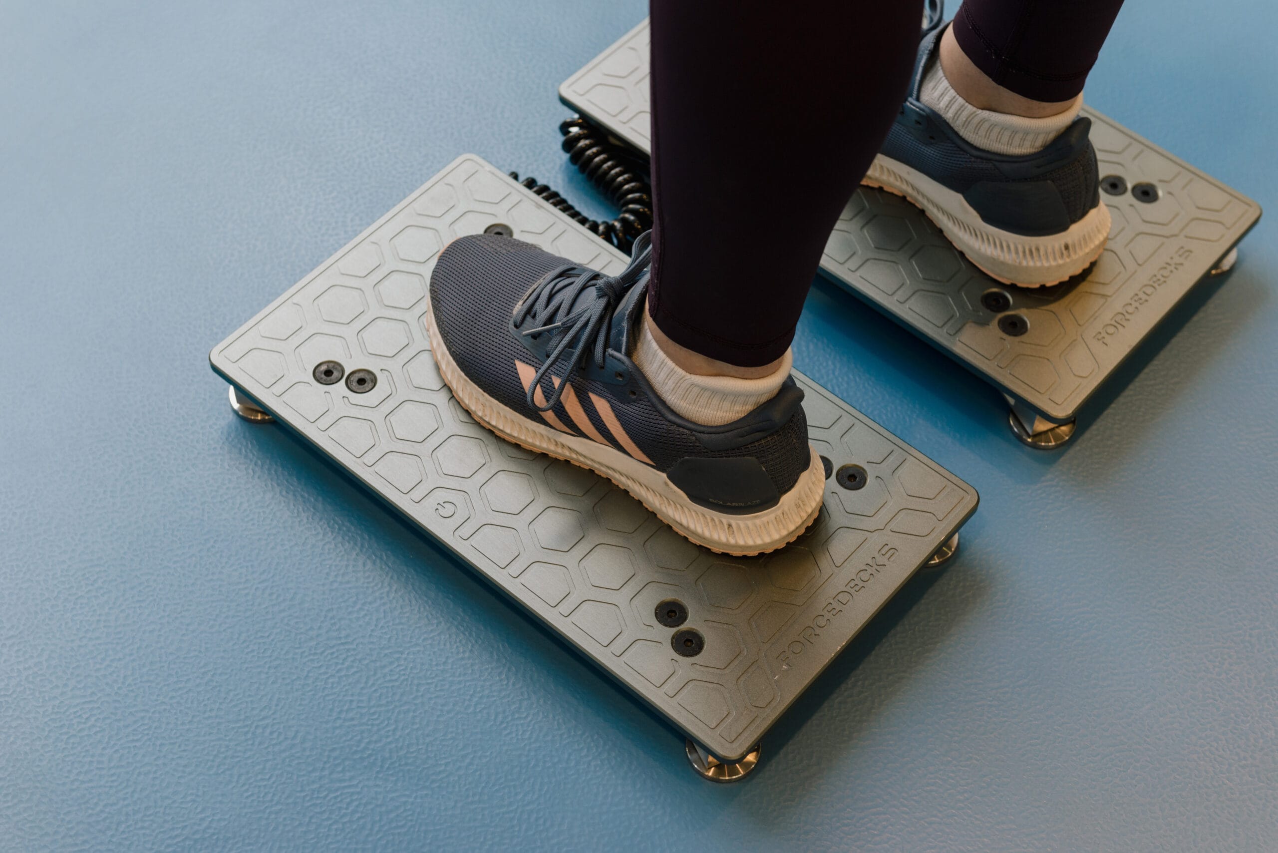 feet with trainers on stood on force decks