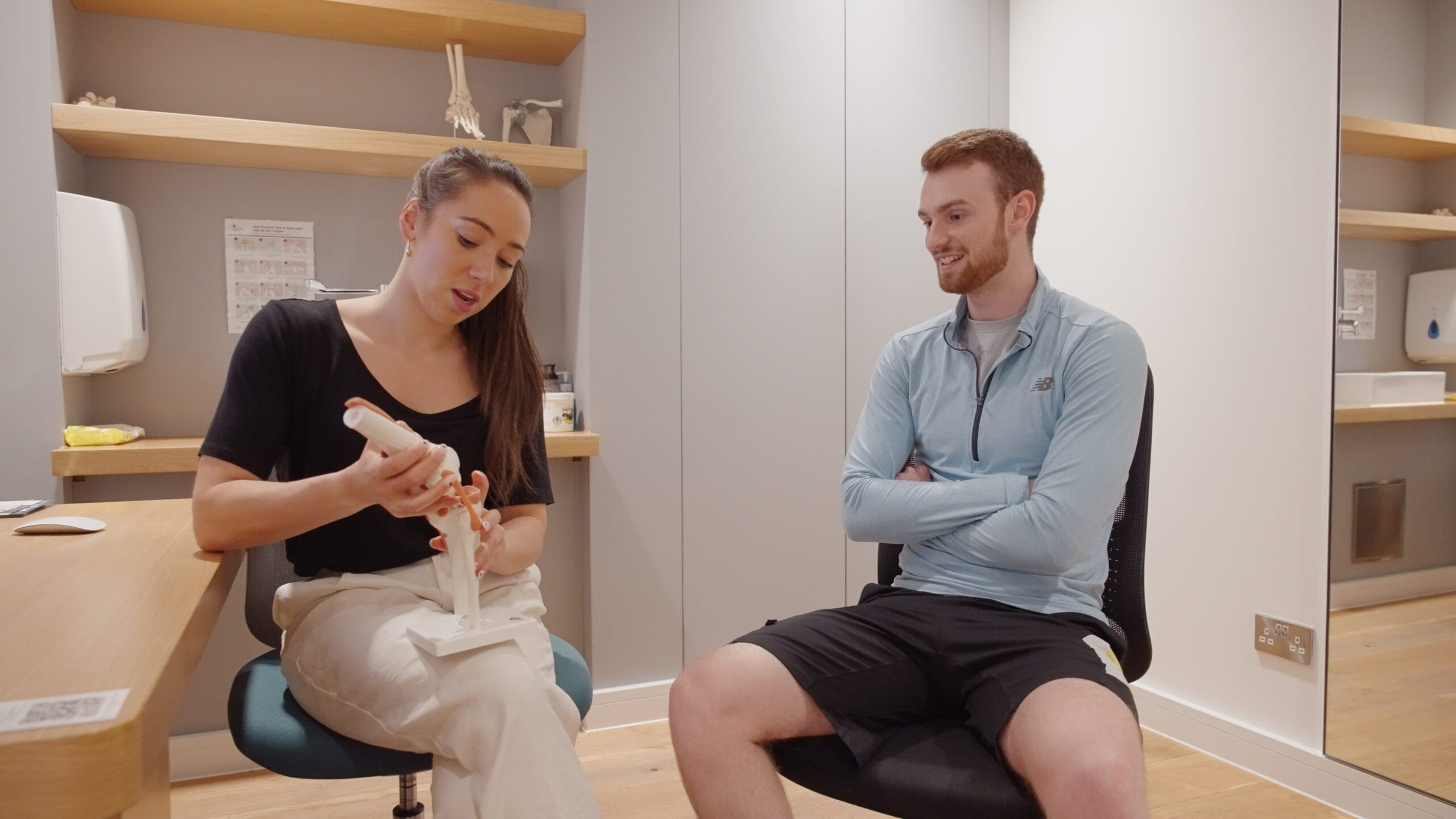 clinician showing the patient a model of the body for osteopathy