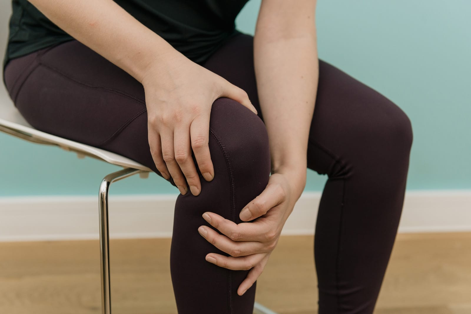 person holding knee with both hands